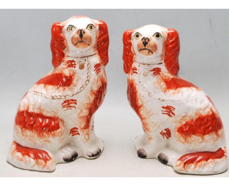 A pair of 19th century Victorian ceramic Staffordshire dogs / mantel pieces dogs in red colourway with gilded collar and lid.