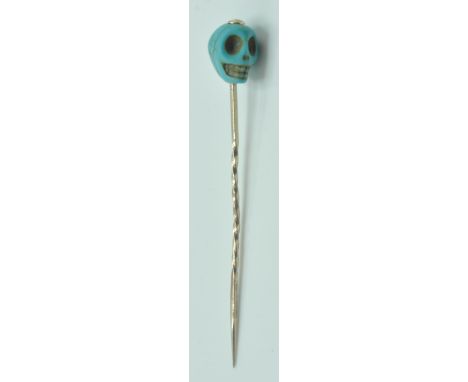 A 19th Century Victorian turquoise and gold stick pin having a carved turquoise finial top in the form of a skull on a twiste
