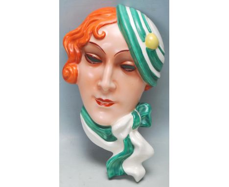 An early 20th century Czechoslovakian Art Deco hand painted ceramic wall plaque of a girl wearing a tilted hat. Impressed num
