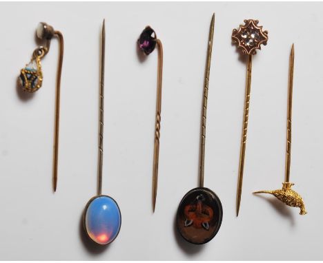 A group of six 20th Century various gilt stick pins to include a painted fox finial pin, moonstone pin, purple stone pin, a p