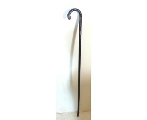 An antique late 19th century Victorian gentleman's walking stick / cane. Ebonised shaft, with a small hallmarked silver colla