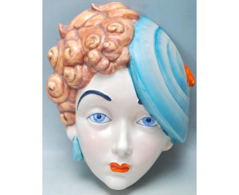 A 1930s Art Deco early 20th Century ceramic polychrome wall plaque of a girl wearing a beret, printed backstamp. Measures 23c