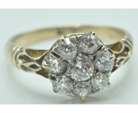 A 19th Century Victorian 18ct gold and diamond cluster ring set with seven old cut diamonds surrounding a principle diamond t