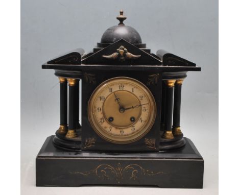 An antique circa 1900 early 20th century slate mantel clock having a domed finial raised on a pediment top over six column su