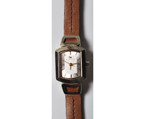 A designer ladies wristwatch by Radley having a brushed steel face with a brass baton numerals to the chapter ring. Watch com