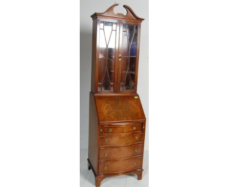 An antique style Georgian revival mahogany ladies bureau bookcase having a pediment top over twin astragal glazed doors openi