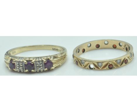 Two hallmarked 9ct gold rings. To include a three stone ring set with round mixed cut ruby having diamond accents. Together w