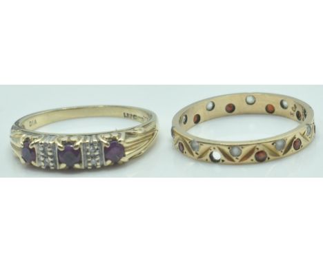 Two hallmarked 9ct gold rings. To include a three stone ring set with round mixed cut ruby having diamond accents. Together w