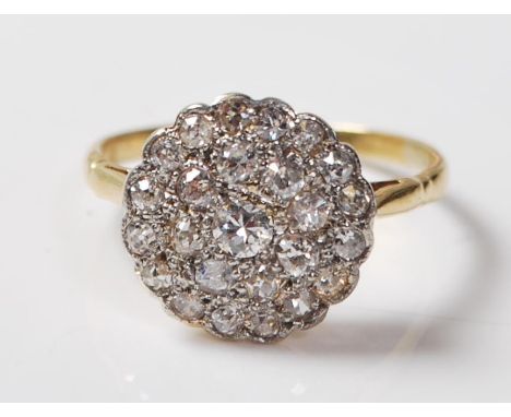A gold and diamond cluster ring. The ring set with a central round brilliant diamond having further round brilliant cut diamo