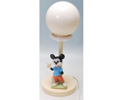 A retro vintage Disney Mickey Mouse lamp having a globular shaped light shade set on a column shaped support raised on circul