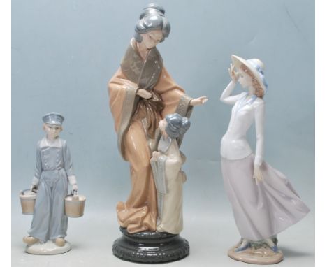 A collection of three vintage late 20th century porcelain figurines comprising of a large Nao Japanese figure of a mother and