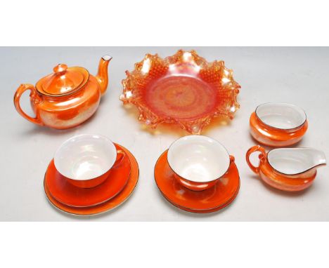 A vintage 20th century Czechoslovakian A Porlith L ceramic tea set in vibrant orange colour comprising of a teapot, sugar bow