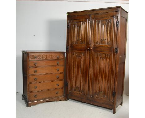 A mid 20th century Jacobean revival linenfold wardrobe having a flared chamfered edge over a double door opening to reveal a 