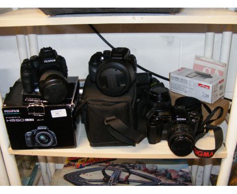A Sigma SA-300 film camera, Fujifilm Finepix S100 FS and HS50 EXR digital cameras, lenses and other photography accessories