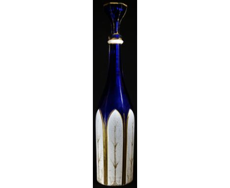 A 19th century Bohemian white overlaid blue glass slender facetted mallet shaped decanter, the lower section with pointed arc