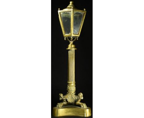 A 19th century bronze table top lantern, glazed hexagonal lamp head, reeded pillar, tripod support with lion paw feet, incurv