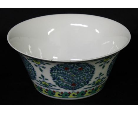 A Chinese wucai flared bowl, painted with stylised trees, flowers and scroll lappets, 16cm diam, seal mark 