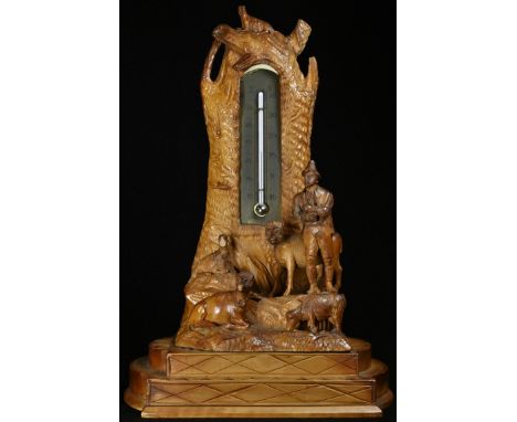 A Black Forest table top thermometer, carved with a Tyrolean shepherd and his flock, 24cm high, c.1900 