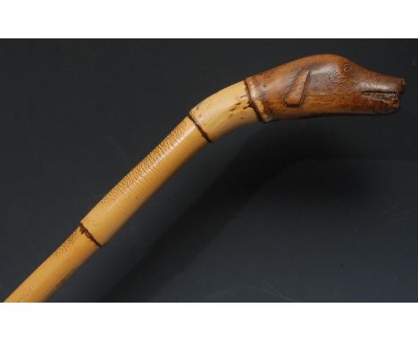 An early 20th century novelty walking stick, the pommel carved as the head of a dog, bamboo cane, 98cm long 