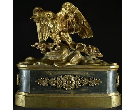 A French Empire gilt and dark patinated bronze chenet, crested by an eagle, 28cm wide, 19th century 