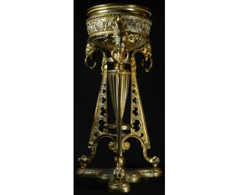 A 19th century gilt brass triform table lamp base, in the Etruscan Revival taste, palmette frieze with loose-ring lion masks,