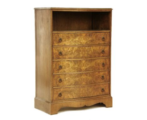 A reproduction walnut chest, the serpentine front with a shelf over five long drawers and bracket feet, 85cm wide x 123cm hig