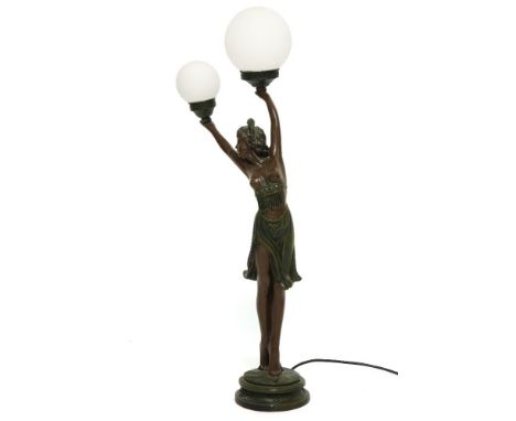 An Art Nouveau style bronzed figural table lamp, in the form of a semi clad female holding the light fittings above her head