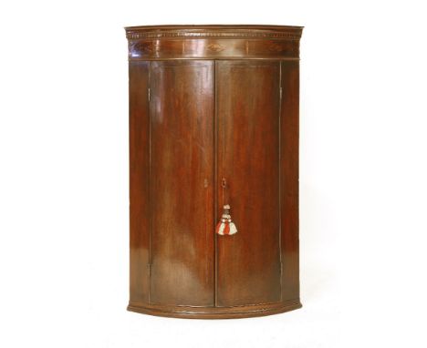 A Georgian mahogany and inlaid bow front corner cupboard, 71 x 50 x 115cm