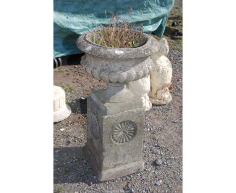 A concrete urn planter on pillar, 18" diameter x 35" high.