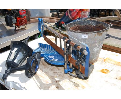 Galvanised bucket, outside light and a mitre saw.
