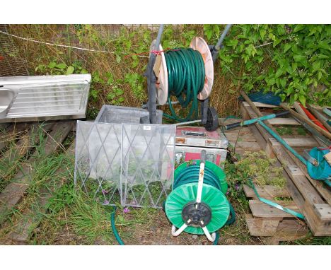 A fibre glass planter, two hoses with reels and two lead lights.