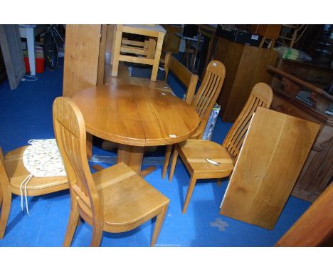 An Extendable Circular Dining Table, extending with a separate leaf, together with four matching high-back chairs, in light O