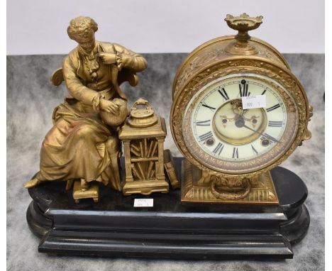 A late 19th century gilt metal American open-face 8-day mantel clock on a wooden stand with Roman numerals and a figure looki