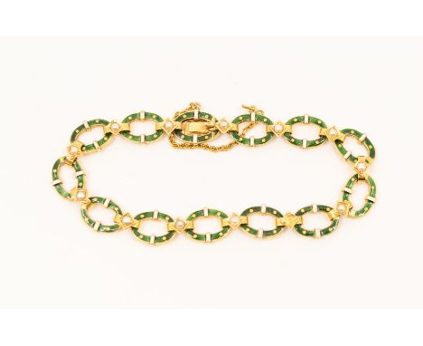 An early 20th century enamel and 18ct gold bracelet, comprising open oval links of green guilloche enamel and white enamel ba