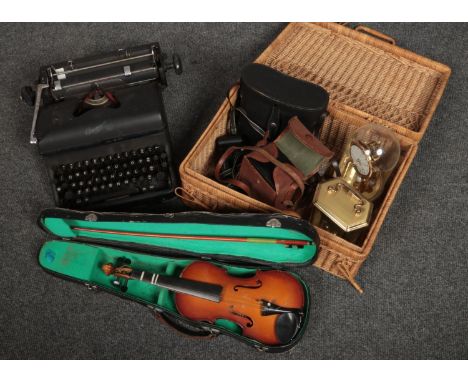 A wicker basket with contents of clocks, cameras, cased Lark violin, typewriter etc.  