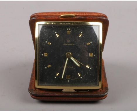 A Junghans folding travelling bedside alarm clock. With black dial and gilt baton markers, 6cm square.  