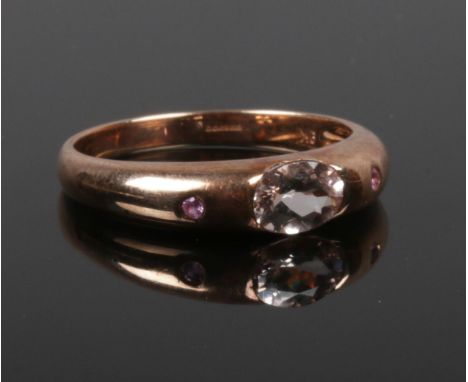 A 9ct rose gold, morganite and ruby three stone ring with rub over setting. Size R.  