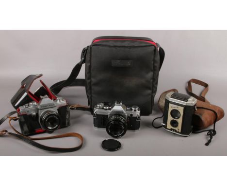 A Canon AE-1 slr camera with Canon 50mm lens, a Praktica L2 slr camera and Gorlitz lens and a Brownie camera.  