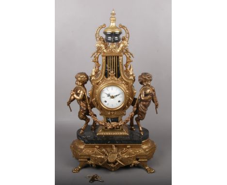 A French style gilt cast metal lyre mantel clock, the convex enamelled two train movement inscribed Imperial, flanked by two 