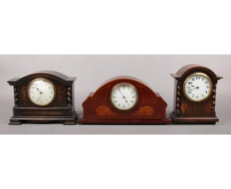 A mahogany cased dome top mantel clock inlaid with walnut and stringing. Along with two oak cased mantel clocks with barley t