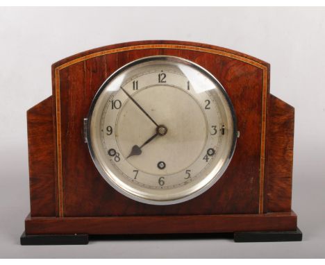 An Art Deco mahogany cased 8 day Westminster mantel clock having strike / silent function. With silvered dial, satinwood band
