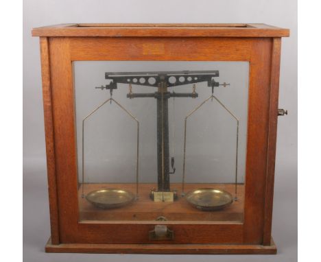 An oak cased set of Philip Harris Ltd scientific balance scales.  Glass in top missing.