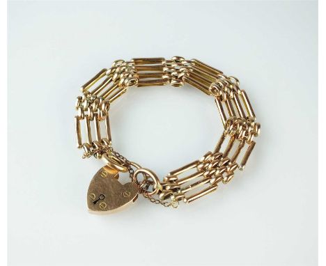 A yellow metal four bar gate link bracelet, the padlock clasp stamped '9ct', with attached safety chain, weight approx 21.5g