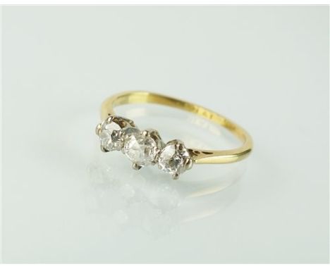 A three stone diamond ring, the three old cut graduated diamonds claw set in white metal to yellow metal shank, stamped '18ct