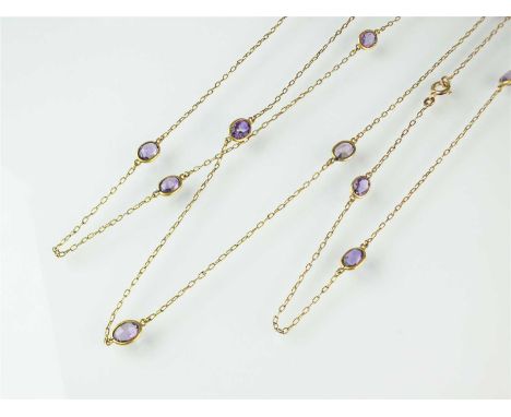 An amethyst set chain necklace, comprised of sixteen oval mixed cut amethysts mounted in yellow metal to oval link chain, the