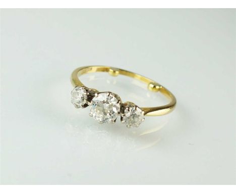 A three stone diamond ring, the central brilliant cut diamond flanked to each side by a graduated old cut diamond, all claw s