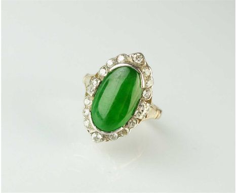 A jade and diamond cluster ring, designed as a central oval jade cabochon mounted within graduated old cut diamond border, th