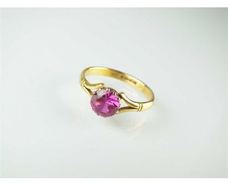 A 22ct gold synthetic pink sapphire single stone ring, the round mixed cut pink sapphire claw set in yellow gold, the yellow 