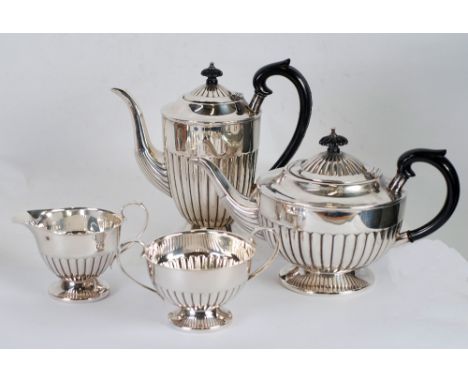 FOUR PIECE SILVER TEA AND COFFEE SET, of circular, part fluted footed form with black scroll handles and knops, Sheffield 197