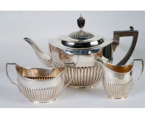 THREE PIECE EARLY TWENTIETH CENTURY SILVER TEA SET, by Hutton and Sons, of oval, part fluted form with angular scroll handles